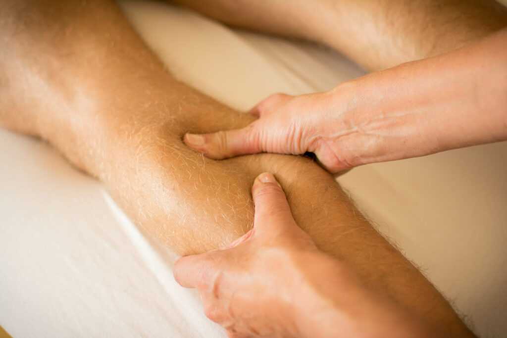 Massage therapist applying pressure to reduce muscle knots