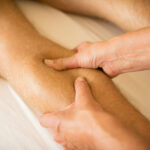 Massage therapist applying pressure to reduce muscle knots