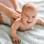 Massage for the baby. Four month old baby smiling doing gymnasti